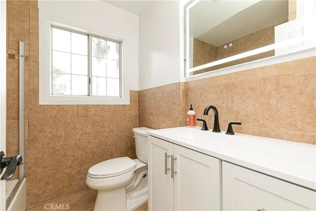 bathroom featuring tile walls, shower / bathing tub combination, toilet, vanity, and tile patterned flooring