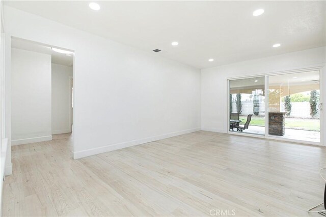 unfurnished room featuring light wood-type flooring, visible vents, baseboards, and recessed lighting