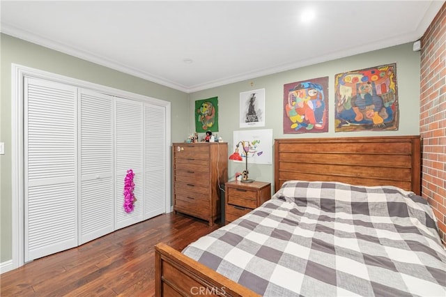 bedroom with a closet, dark wood finished floors, and crown molding