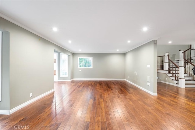 interior space with stairs, hardwood / wood-style floors, ornamental molding, and baseboards