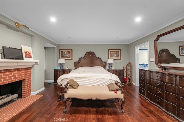 bedroom with dark wood finished floors, recessed lighting, ornamental molding, a brick fireplace, and baseboards