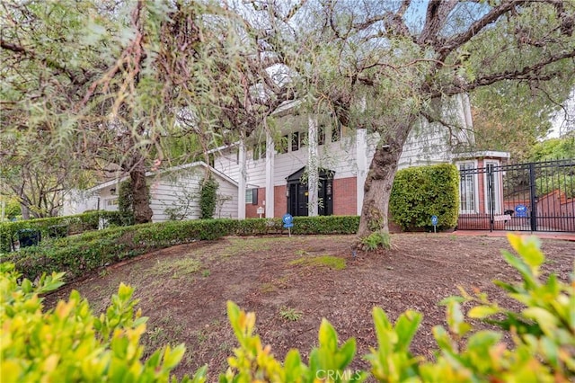 view of front of property featuring fence and brick siding