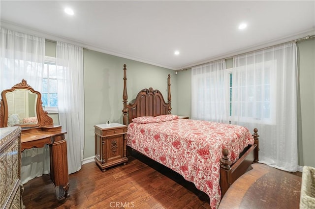 bedroom with dark wood-style floors, ornamental molding, baseboards, and recessed lighting