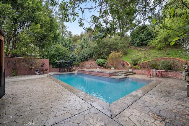 view of swimming pool with a patio, fence, and a fenced in pool