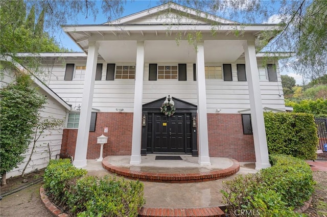 view of front of property featuring a porch and brick siding