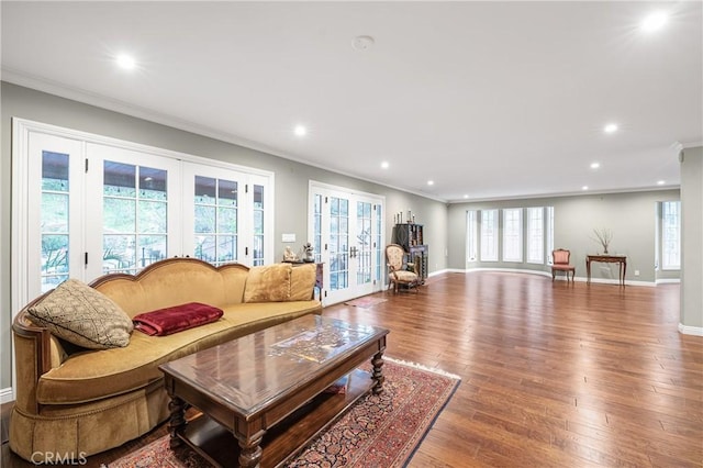 living room with plenty of natural light, french doors, wood-type flooring, and crown molding