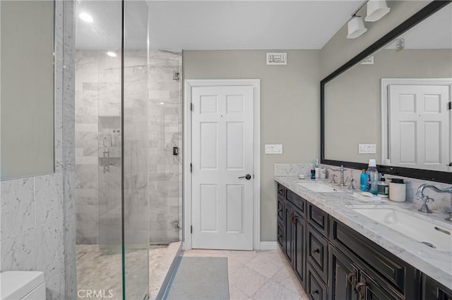 bathroom featuring a stall shower, a sink, and double vanity