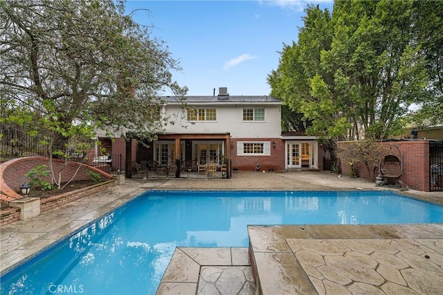 view of swimming pool with a fenced in pool, a patio area, french doors, and a fenced backyard