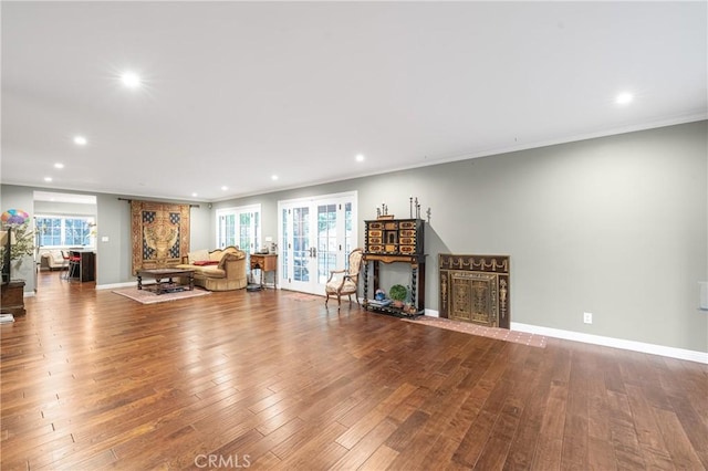 unfurnished living room with french doors, plenty of natural light, hardwood / wood-style flooring, and baseboards