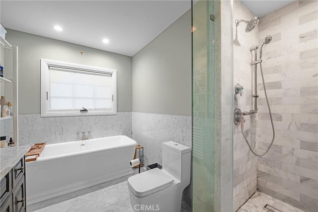 bathroom with toilet, a wainscoted wall, a tile shower, a freestanding tub, and tile walls