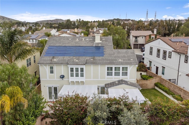 rear view of property featuring a fenced backyard, a residential view, and stucco siding