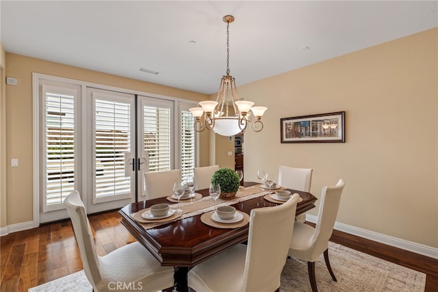 dining area featuring visible vents, baseboards, and wood finished floors