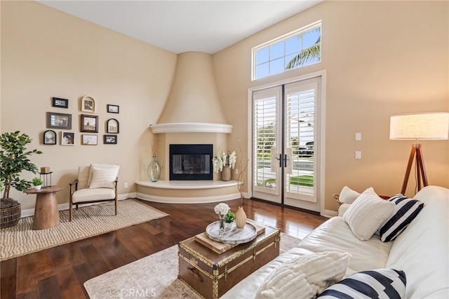 living room with a large fireplace, baseboards, and hardwood / wood-style flooring