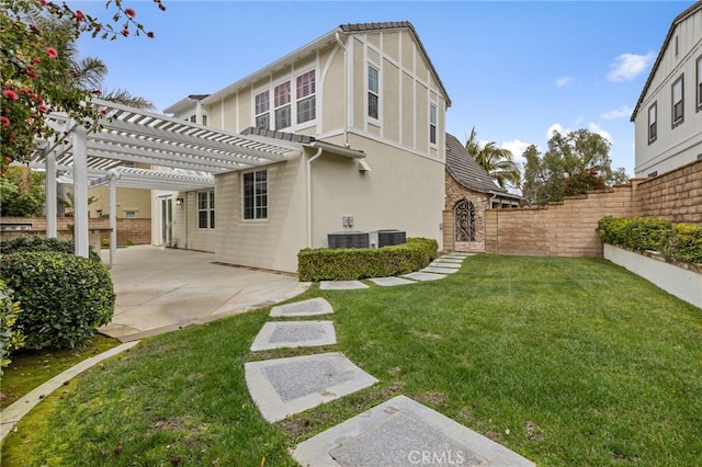 back of house featuring a patio, fence private yard, a yard, a pergola, and stucco siding