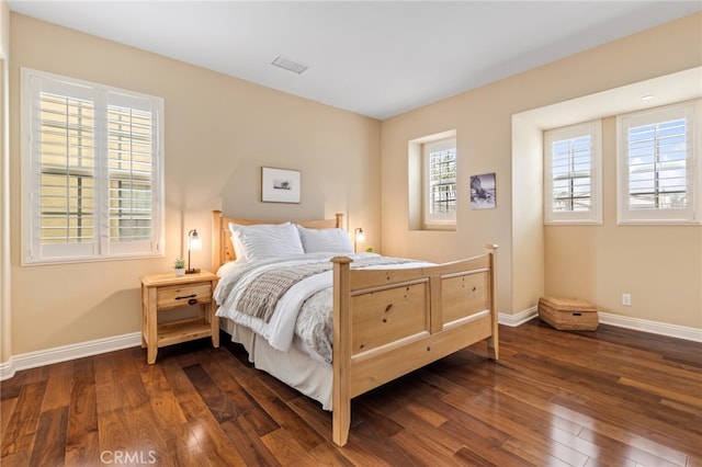 bedroom with dark wood-style floors, baseboards, and visible vents