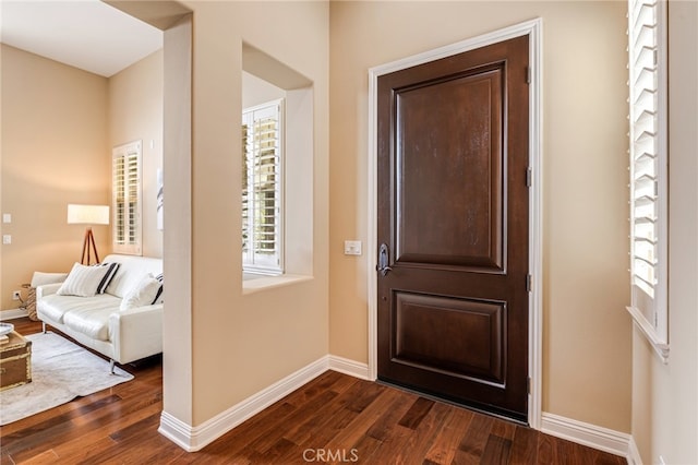 foyer entrance featuring dark wood finished floors and baseboards