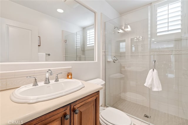 full bath featuring a shower stall, toilet, and vanity