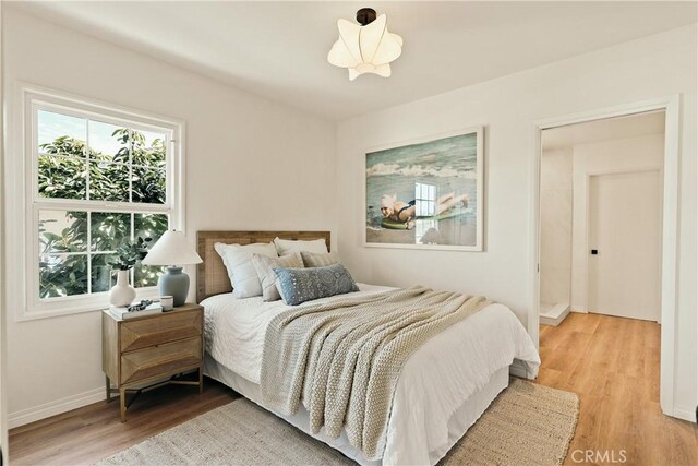 bedroom featuring light wood-style floors and baseboards