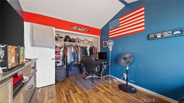 office space featuring baseboards, vaulted ceiling, and wood finished floors