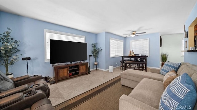 tiled living area with a ceiling fan and baseboards