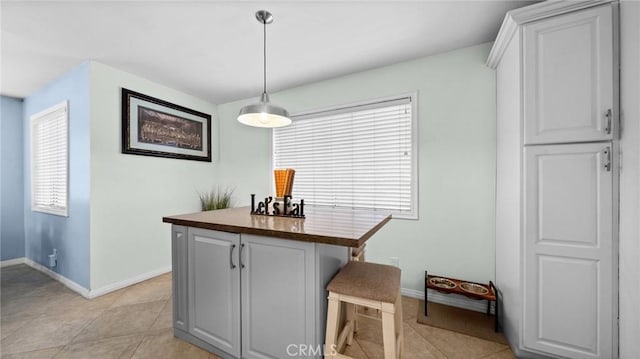 dining space with baseboards and light tile patterned floors