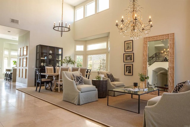 living room featuring visible vents, a high ceiling, and a chandelier