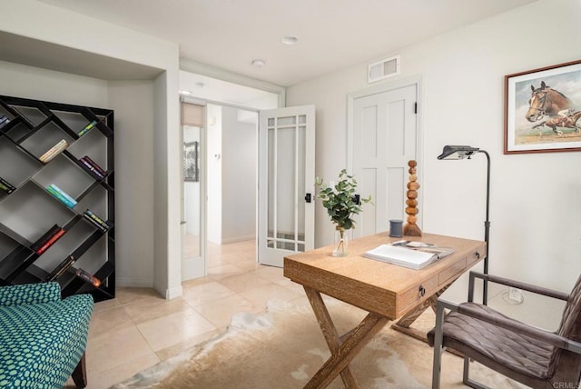 home office featuring light tile patterned floors, visible vents, and baseboards