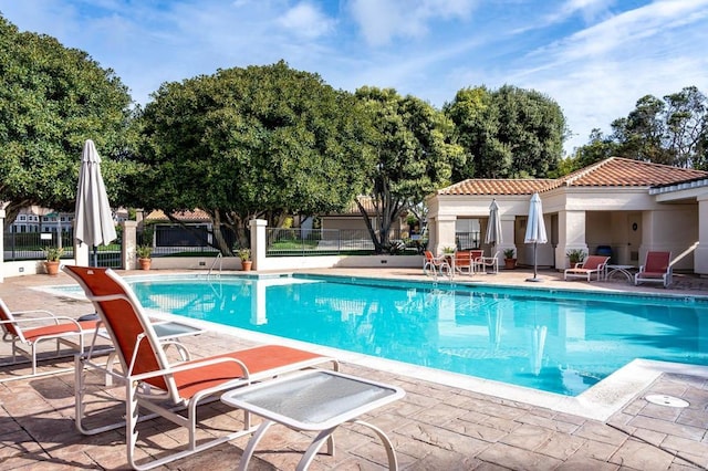 community pool featuring a patio area and fence