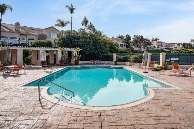 pool featuring fence and a patio area
