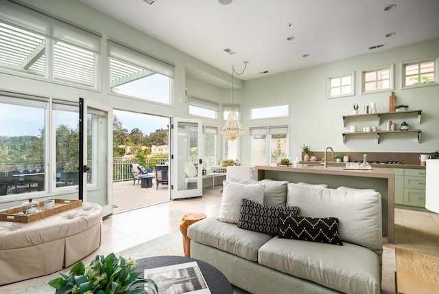 living room with light tile patterned floors, visible vents, recessed lighting, and a high ceiling