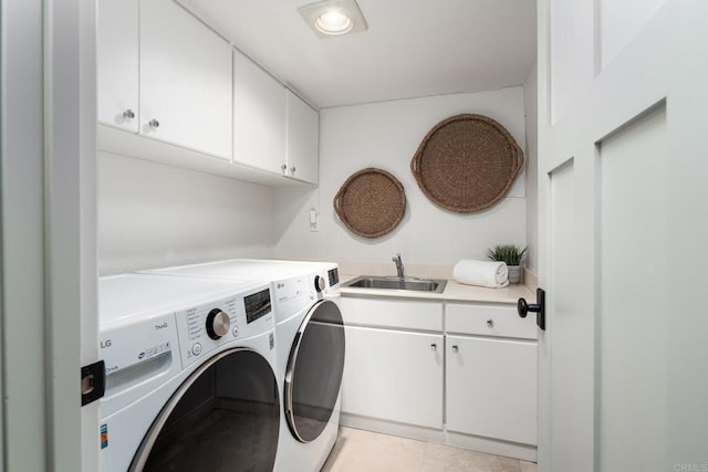 clothes washing area with washer and clothes dryer, cabinet space, light tile patterned flooring, and a sink