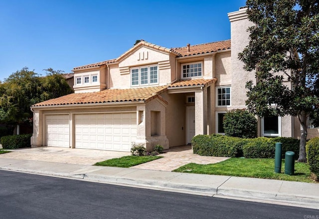 mediterranean / spanish-style home with a tile roof, concrete driveway, stucco siding, a chimney, and an attached garage