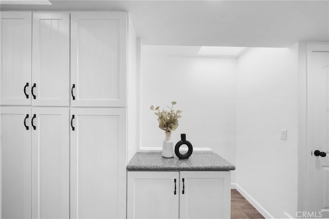 interior details featuring a skylight, baseboards, and wood finished floors