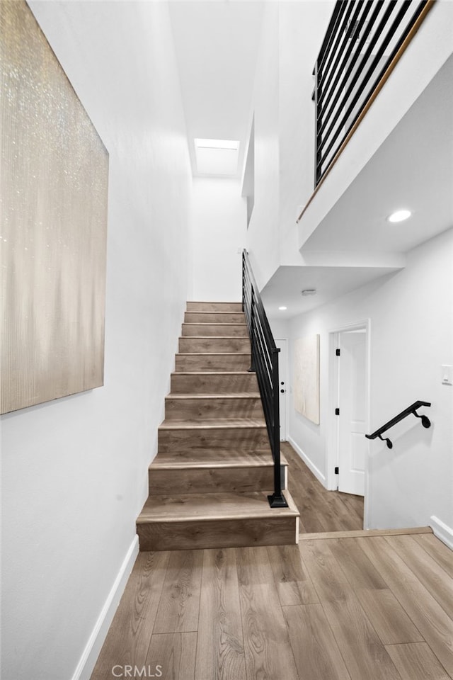 staircase with wood finished floors and baseboards