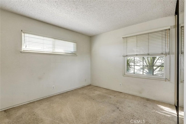 unfurnished room featuring carpet floors and a textured ceiling