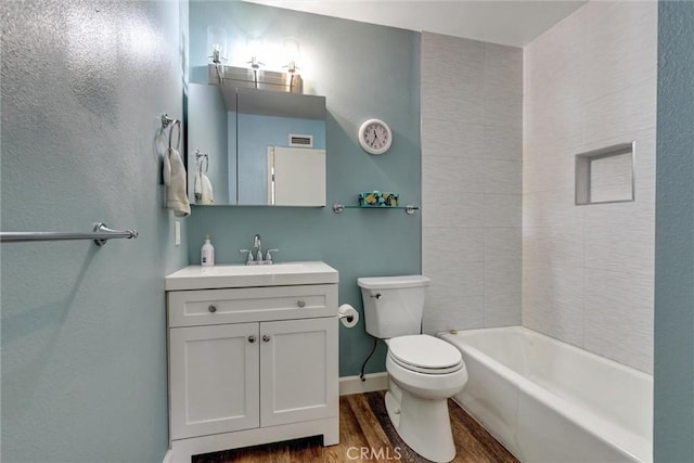 bathroom with visible vents, toilet, wood finished floors, vanity, and shower / bathtub combination