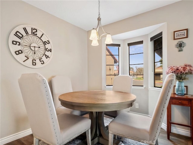 dining area with a notable chandelier, baseboards, and wood finished floors