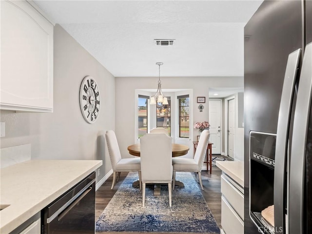 dining area with dark wood-style floors, baseboards, visible vents, and a chandelier