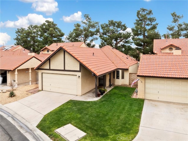 view of front facade featuring an attached garage, a tile roof, a front yard, and stucco siding