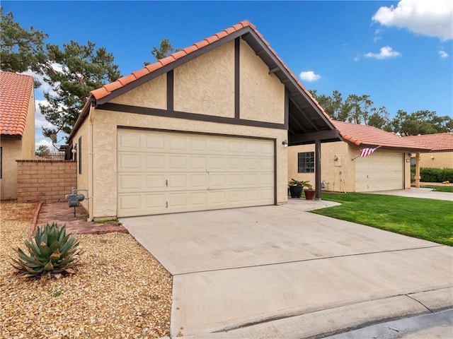 view of front facade with driveway, a tiled roof, and stucco siding