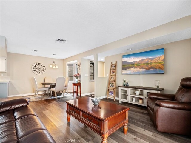 living room with visible vents, baseboards, and wood finished floors