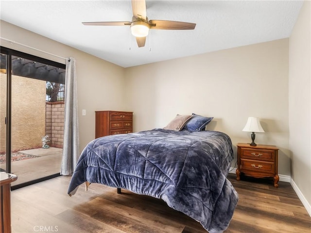 bedroom featuring baseboards, wood finished floors, a ceiling fan, and access to exterior