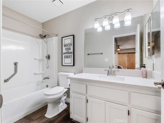 full bathroom with visible vents, toilet, vanity, wood finished floors, and  shower combination