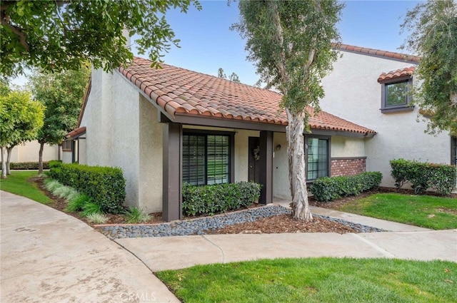 mediterranean / spanish-style house with a tiled roof and stucco siding