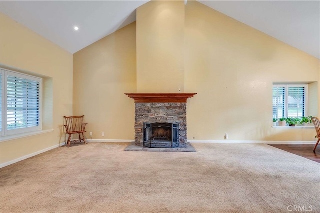 unfurnished living room featuring high vaulted ceiling, a wealth of natural light, a fireplace, and baseboards