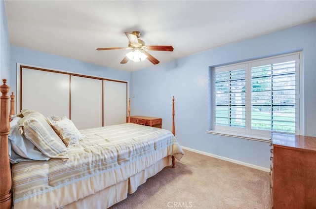 carpeted bedroom featuring a closet, ceiling fan, and baseboards