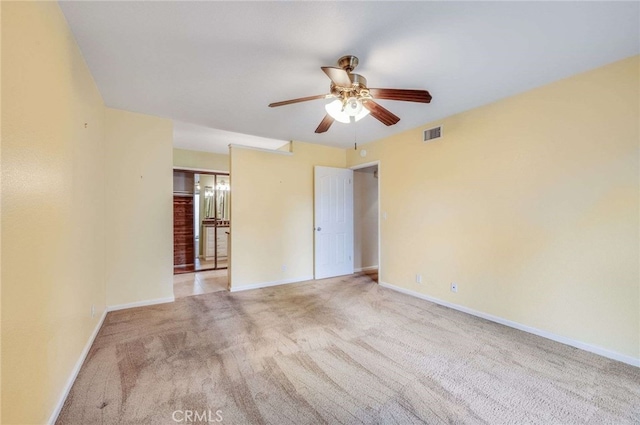 empty room with light carpet, baseboards, visible vents, and a ceiling fan