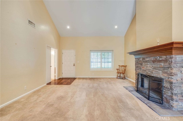 unfurnished living room featuring carpet, high vaulted ceiling, a fireplace, and visible vents