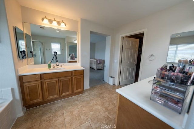 ensuite bathroom with a stall shower, tile patterned flooring, plenty of natural light, and vanity