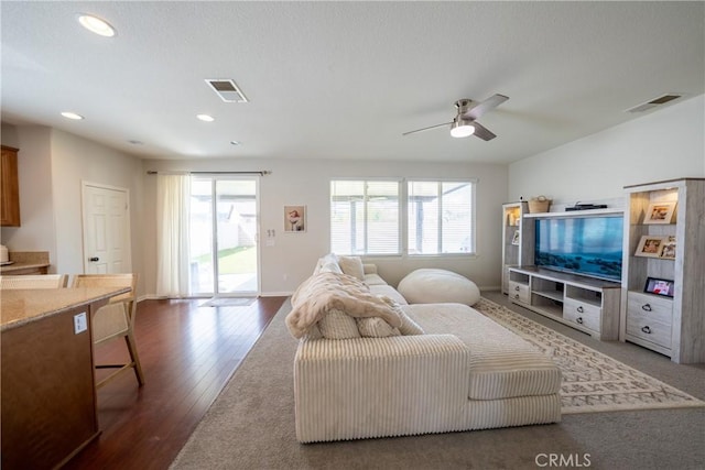 living area with a wealth of natural light, wood finished floors, and visible vents